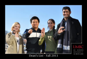 Four students signing "UMBC" in American Sign Language