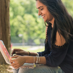 A student working on her laptop outside