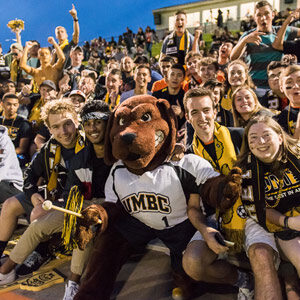 Students enjoying a game a the stadium with the school's mascot True Grit